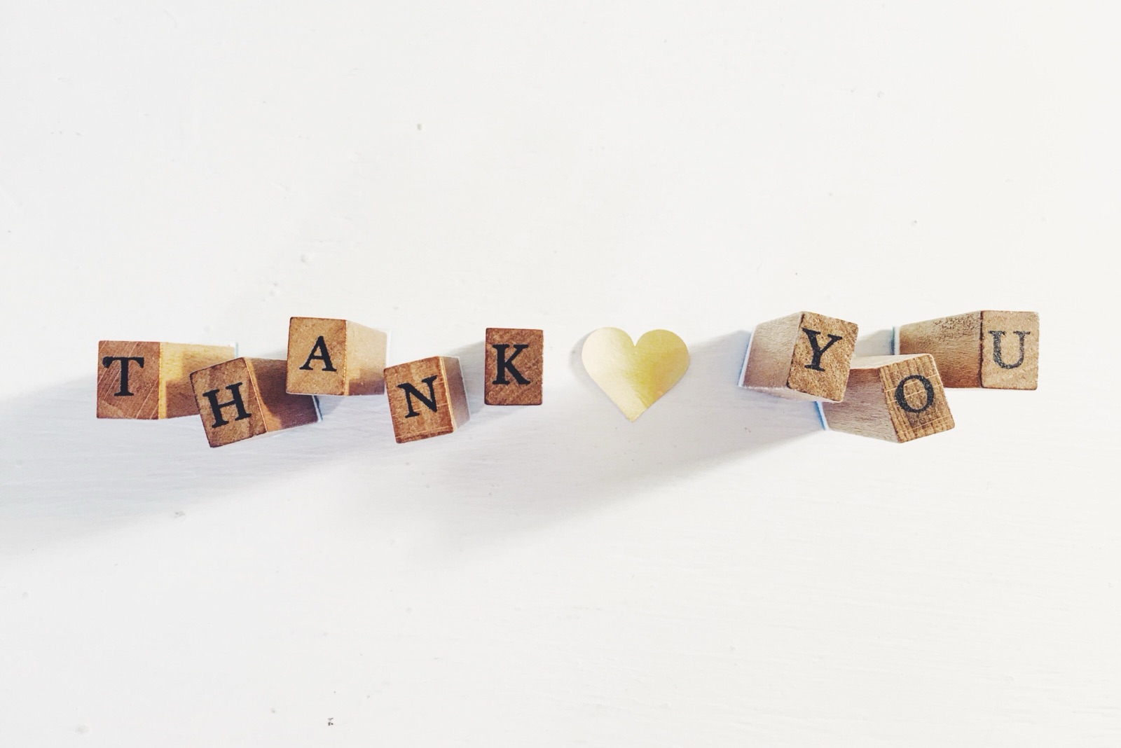 Letter blocks spelling Thank You around a gold heart